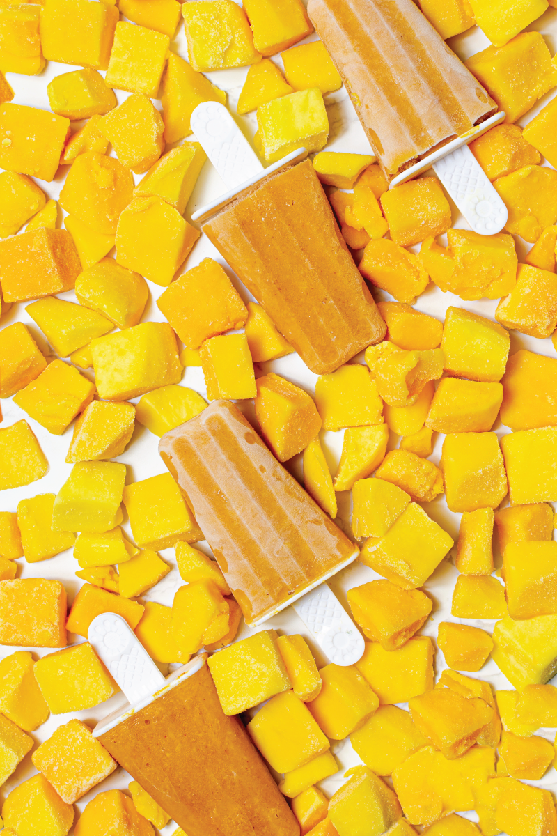 an overhead shot of mango popsicles surrounded by mangos